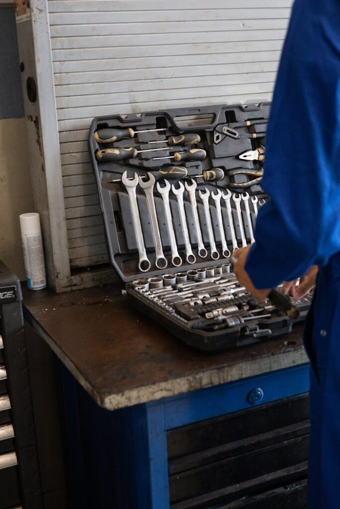 pexels photo 8985910 Mechanic in blue overalls organizing a toolset in an industrial workshop.